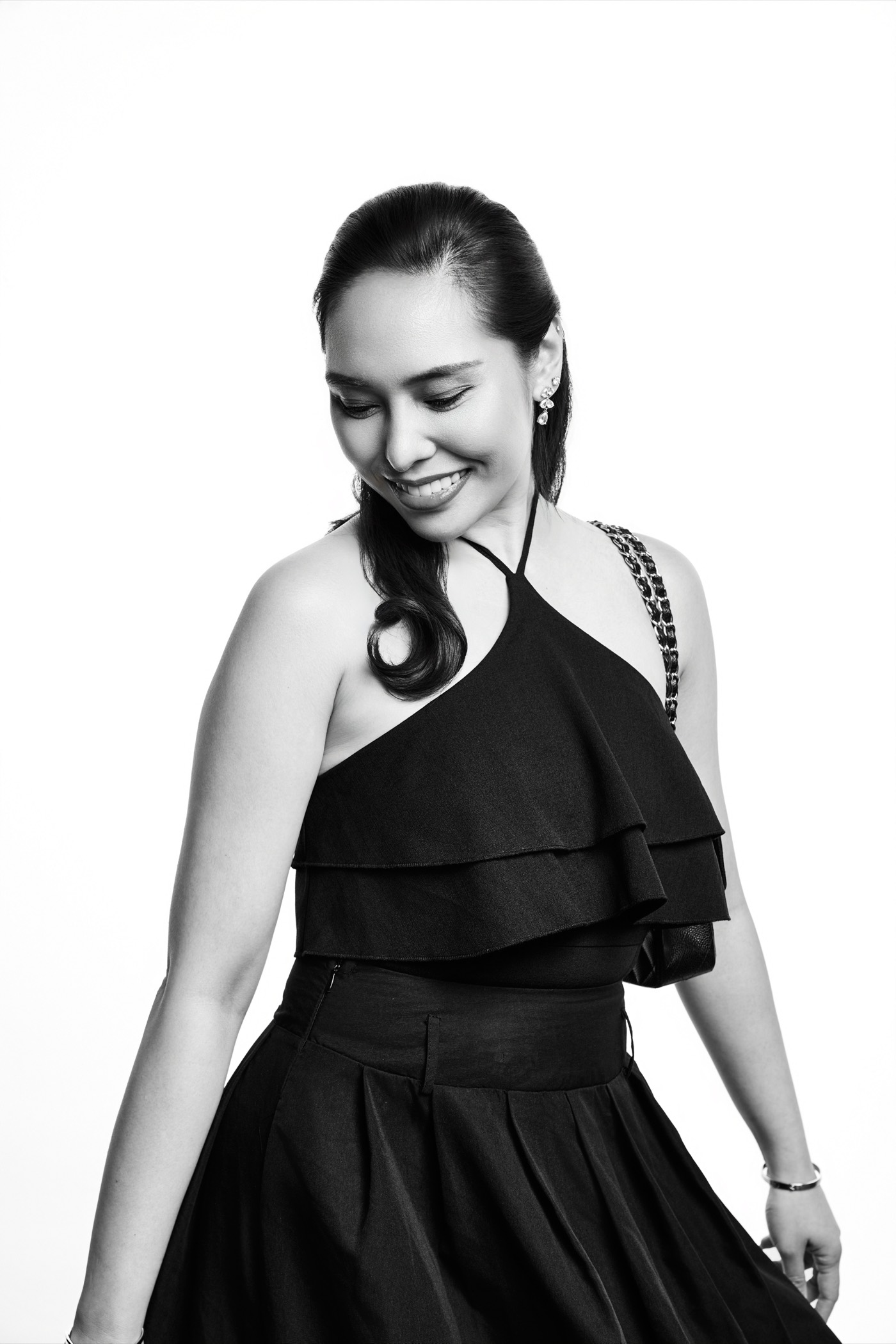 Full-length studio portrait of a guest in a black gown against the signature white backdrop